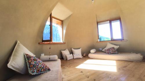 a room with pillows and a couch in a room with windows at Nautilus Ecocasa Lago Puelo in Lago Puelo