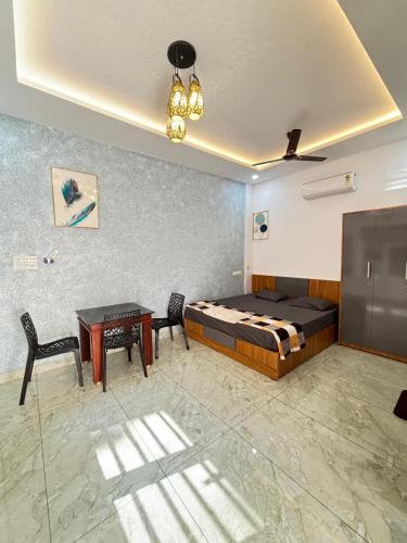 a bedroom with a bed and a table and chairs at GRAYSTONE HOMESTAY, Omassery in Tāzhekkod