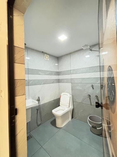 a bathroom with a toilet and a shower and a sink at GRAYSTONE HOMESTAY, Omassery in Tāzhekkod