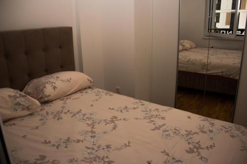 a bedroom with a bed and a mirror at Apartman Doboj in Doboj