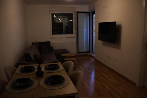 a living room with a table and a couch at Apartman Doboj in Doboj