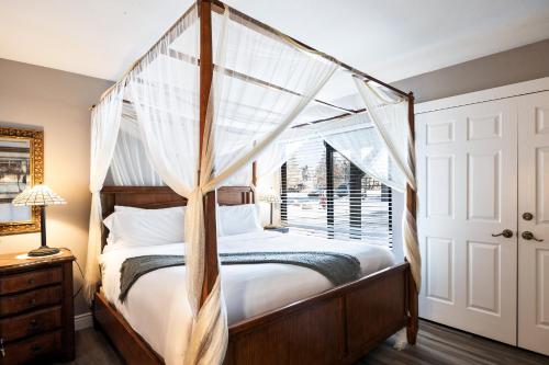 a bedroom with a canopy bed and a window at Hidden Creek Canyons Retreat, Alpine Charm, Private Hot Tub, Sleeps 8, Cozy Fireplace, in Park City