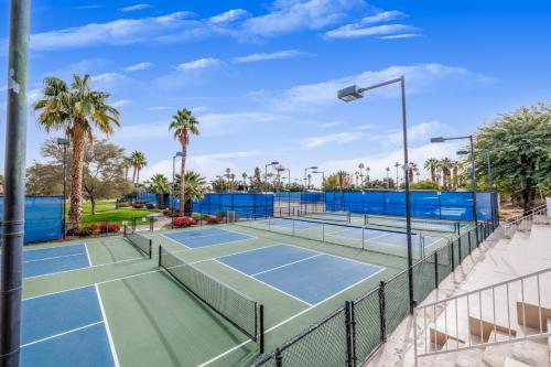 a tennis court at a resort with palm trees at Music Lovers Paradise 7 Bed Pool Home and Game Room in Indio