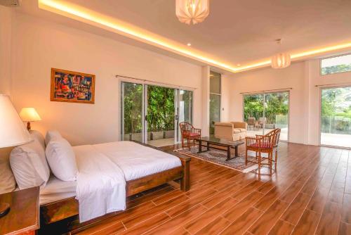 a bedroom with a large bed and a living room at Corner House in Tagaytay
