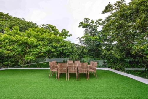 une table et des chaises sur une pelouse verte dans l'établissement Corner House, à Tagaytay