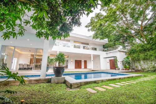 Una vista exterior de una casa con piscina. en Corner House, en Tagaytay