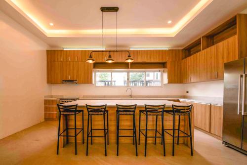 une cuisine avec un grand îlot central et des tabourets de bar dans l'établissement Corner House, à Tagaytay