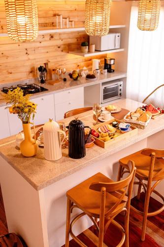a kitchen with a large island with a counter top at Chalé Cruzeiro do Sul, hidromassagem, 2 min Thermas Machadinho-RS#2 in Machadinho