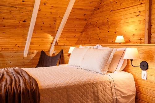 a bedroom with a bed in a wooden room at Chalé Cruzeiro do Sul, hidromassagem, 2 min Thermas Machadinho-RS#3 in Machadinho