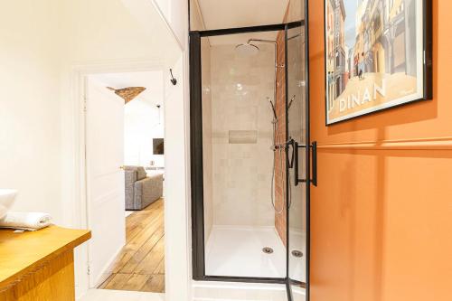 une douche dans une salle de bain avec une porte vitrée dans l'établissement Appartement cosy 4 pers Dinan avec Wifi, à Dinan