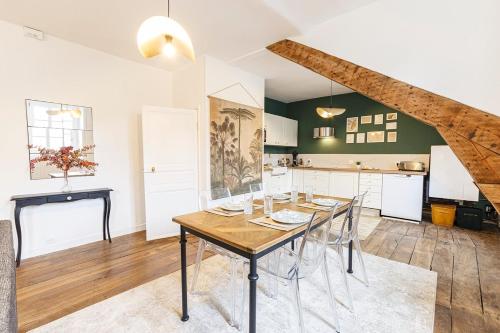 une cuisine et une salle à manger avec une table et des chaises en bois dans l'établissement Appartement cosy 4 pers Dinan avec Wifi, à Dinan