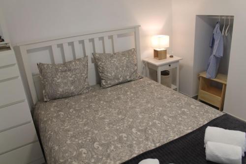 a bedroom with a bed and a night stand with a lamp at Casa das Bonecas by LovelyStay in Évora Monte