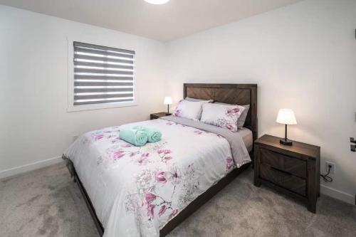 Un dormitorio blanco con una cama grande con flores. en AMAZING Value! Near Downtown, Large 3BR! FREE Banff Pass, Wine, Netflix, Parking! Groups of up to 16 - Ask us!, en Calgary