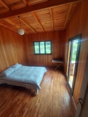 マル・デル・プラタにあるCasa de Marの木製の部屋にベッド1台が備わるベッドルーム1室があります。