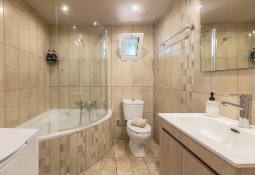 a bathroom with a tub and a toilet and a sink at Hot Tub - 5 min to Beaches - Private Garden - Netflix in Lampi