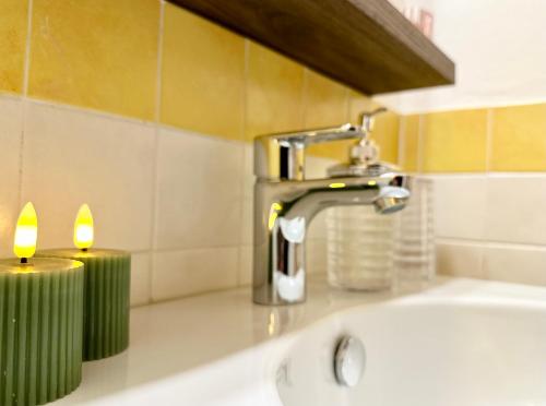 a bathroom sink with two candles next to a faucet at Domus Sofia Historic Center Rimini Apartment in Rimini
