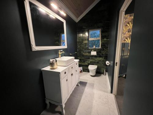a black bathroom with a sink and a toilet at Serenity Suite in Somerset West