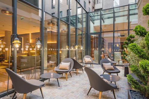 a patio with chairs and tables in a building at La Caserne Chanzy Hotel & Spa, Autograph Collection in Reims
