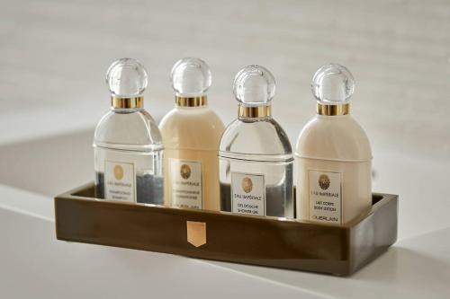 four bottles of soap in a wooden tray at La Caserne Chanzy Hotel & Spa, Autograph Collection in Reims