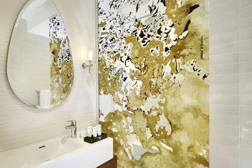 a bathroom with a sink and a mirror at La Caserne Chanzy Hotel & Spa, Autograph Collection in Reims