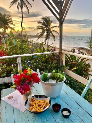 a table with a bowl of french fries and a bowl of beer at Aloha in Icapuí