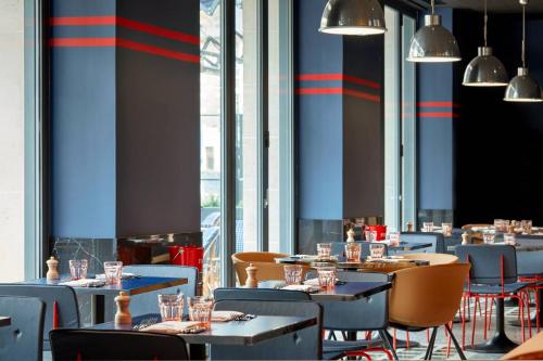a restaurant with blue and red stripes on the walls at La Caserne Chanzy Hotel & Spa, Autograph Collection in Reims