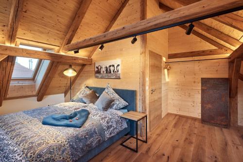 a bedroom with a bed in a room with wooden ceilings at Haus Herzbluat in Peiting