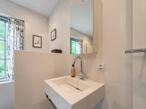 a white bathroom with a sink and a mirror at Mc Ghil in Baarle-Nassau-Grens