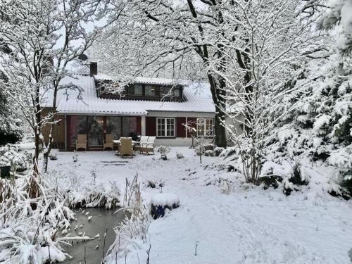 a house covered in snow in front of a yard at Mc Ghil in Baarle-Nassau-Grens