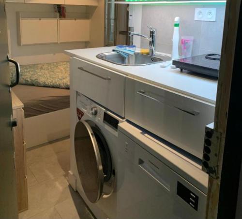 - un lave-linge dans une cuisine à côté d'un évier dans l'établissement NEW Private apartment Paris city center - Les Arènes Pantheon Notre-Dame Jussieu Jardin des Plantes Quai de Seine, à Paris