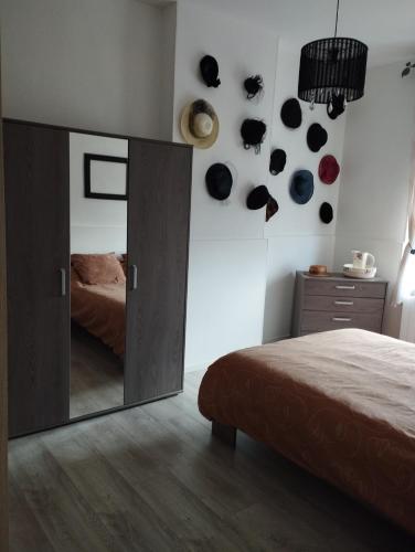 - une chambre avec un grand miroir mural dans l'établissement Appartement GUISE Familistere, à Guise