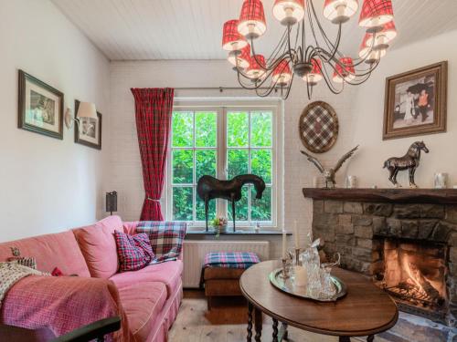 a living room with a pink couch and a fireplace at Mc Ghil in Baarle-Nassau-Grens