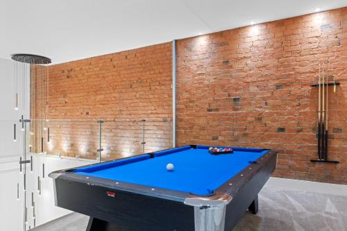 a pool table in a room with a brick wall at Luxury 2-Bed Apartment with Parking & Terrace in Nottingham