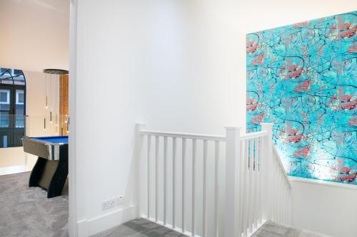ein Flur mit einer Treppe und einem Gemälde an der Wand in der Unterkunft Luxury 2-Bed Apartment with Parking & Terrace in Nottingham