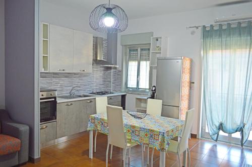 a kitchen with a table with chairs and a refrigerator at Caracol Magico in Rometta Marea