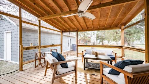 a screened porch with a ceiling fan and chairs and a table at Cheerful 5-bedroom w/Screened Patio, Sleeps 10 in the heart of Fremont! in Fremont