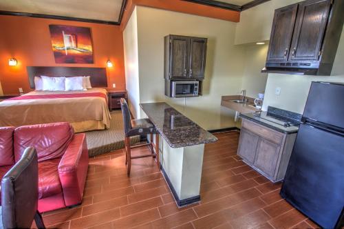 um quarto de hotel com uma cama e uma cozinha em Blue Bay Inn and Suites em South Padre Island