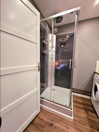 une douche avec une porte vitrée dans une salle de bain dans l'établissement Appartement Résidentiel avec parking/Proche Centre, à Angoulême