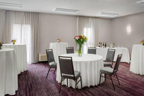 a room with tables and chairs and a vase of flowers at Courtyard Philadelphia Valley Forge / King of Prussia in Wayne