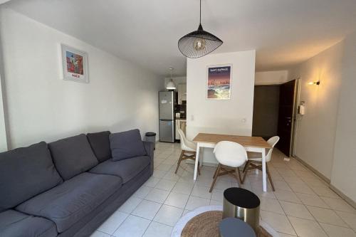 un salon avec un canapé bleu et une table dans l'établissement Apt In The City Center Residence With Pool, à Saint-Raphaël