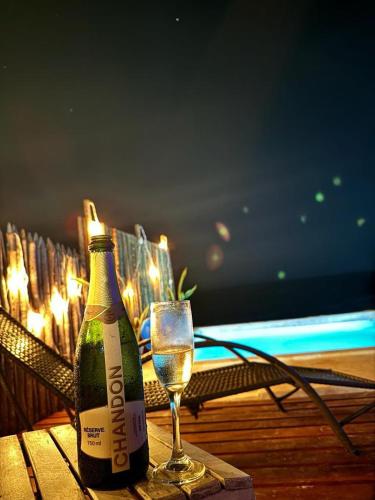 a bottle of champagne and a glass on a table at Aloha in Icapuí