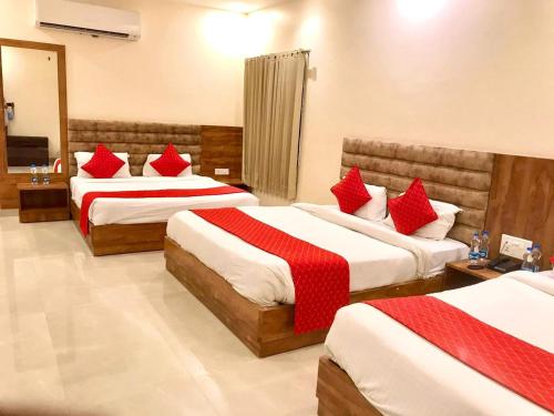 a hotel room with two beds with red pillows at Hampton Hotel - 200 mt from Golden Temple in Amritsar