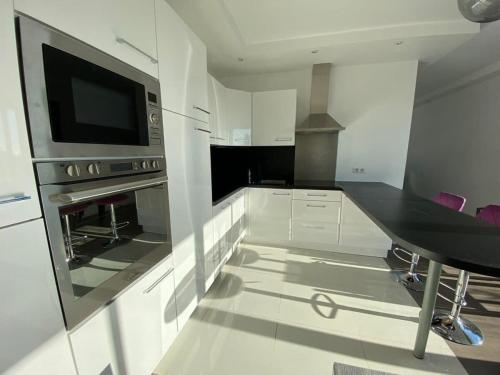 Il comprend une cuisine équipée d'un four micro-ondes et d'une table. dans l'établissement C010 - Magnifique Appartement Toit Terrasse, à Cannes