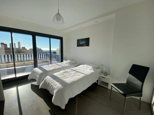 une chambre blanche avec un lit et une chaise dans l'établissement C010 - Magnifique Appartement Toit Terrasse, à Cannes