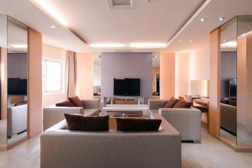 a living room with a couch and a tv at i-Deal Hotel in Taichung