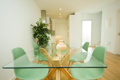 a glass table with green chairs in a room at Casa Olivia - By AZ Rentals in Playa Blanca