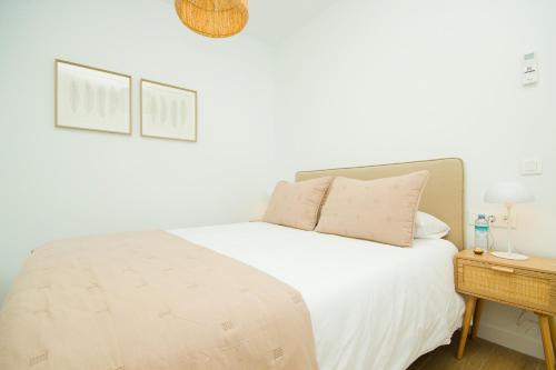 a bedroom with a white bed and a night stand at Casa Olivia - By AZ Rentals in Playa Blanca