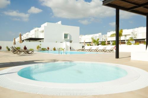 a large swimming pool in a courtyard with a resort at Casa Olivia - By AZ Rentals in Playa Blanca