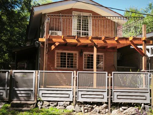 a house with a fence in front of it at Sonidos del Rio Aparts in Santa Rosa de Calamuchita