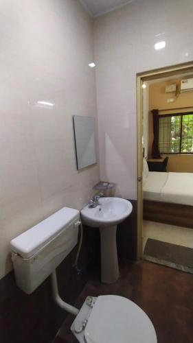 a bathroom with a toilet and a sink at Sk Residency in Bangalore